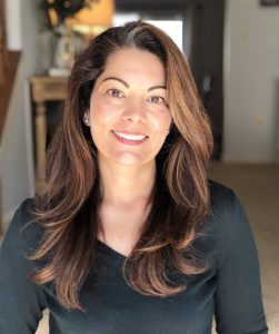 Naturopathic practitioner smiling in a clinic setting.