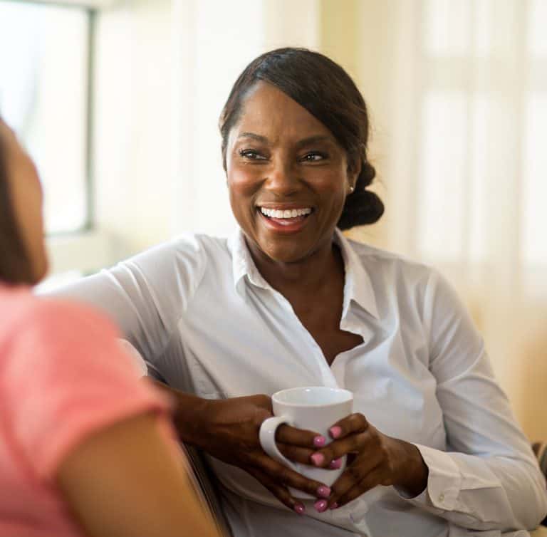 Naturopathic doctor smiling and talking with a patient in a wellness clinic.