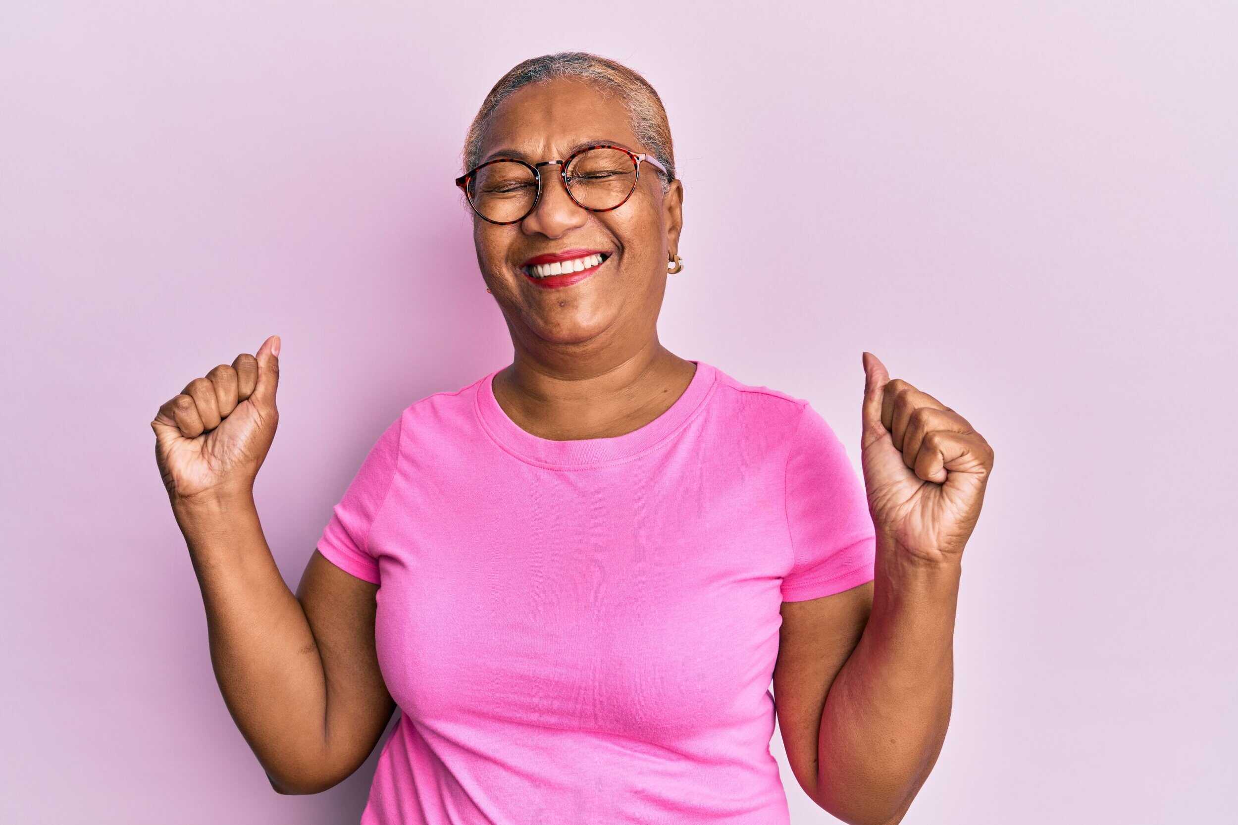 Smiling senior woman with glasses, expressing joy and relief from joint pain.