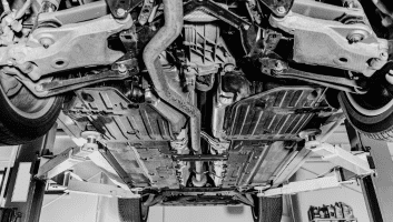 Underbody view of a car on a lift at Tools in Motion Auto repair shop.