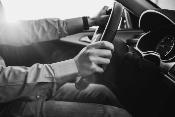 Auto repair technician inspecting a vehicle's dashboard and controls.