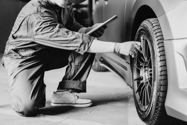 Technician inspecting car tire during tire service at Tools in Motion.
