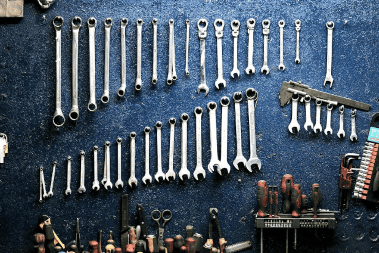 High-quality wrench tools arranged on a blue surface for brake repair and maintenance.