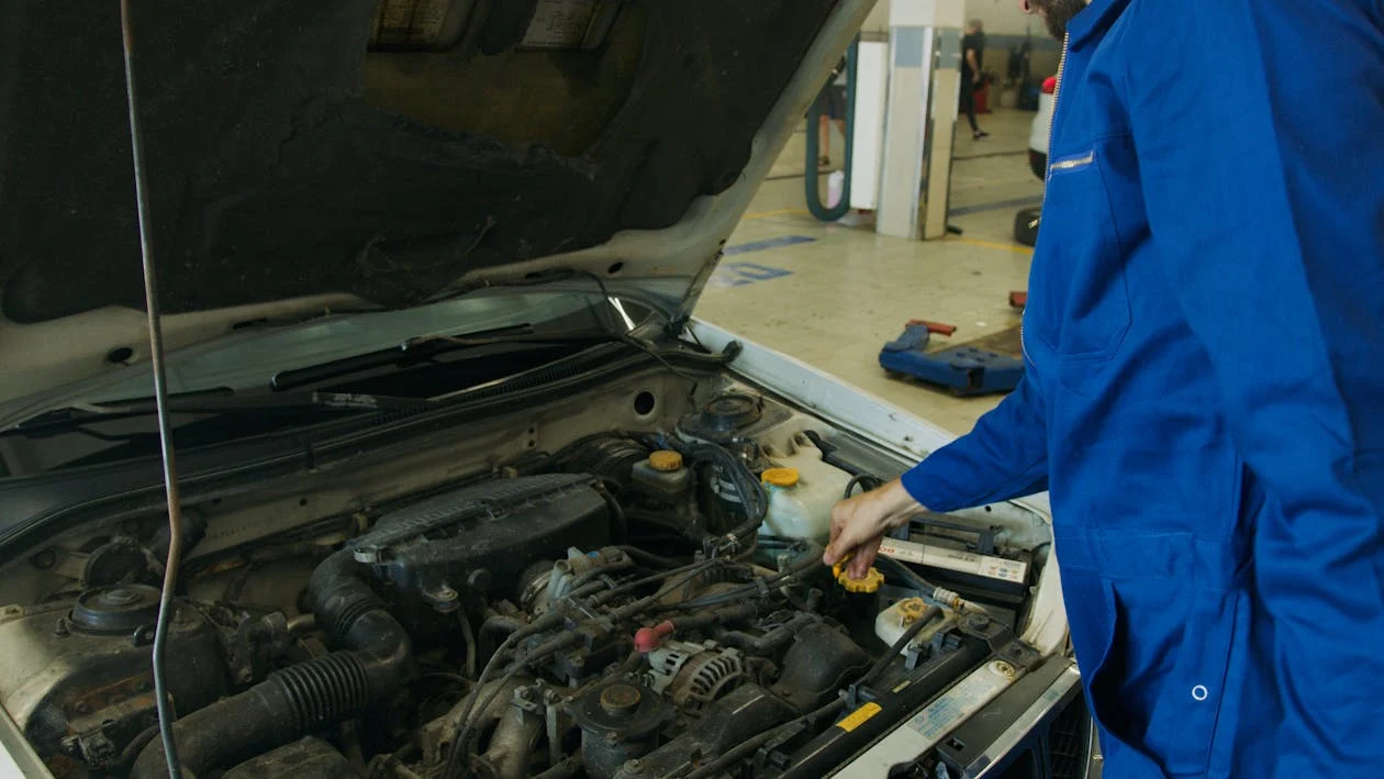 Technician performing advanced auto diagnostics on a vehicle engine.