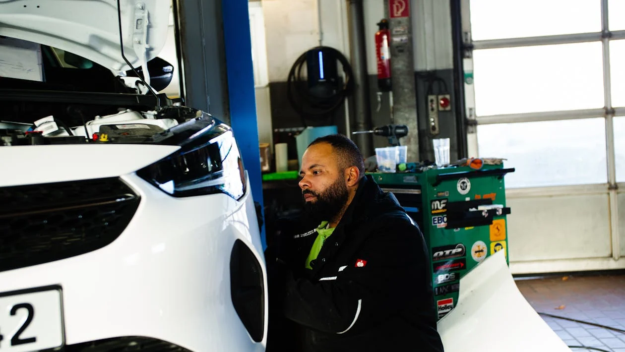 Auto diagnostics technician inspecting a vehicle engine for issues.