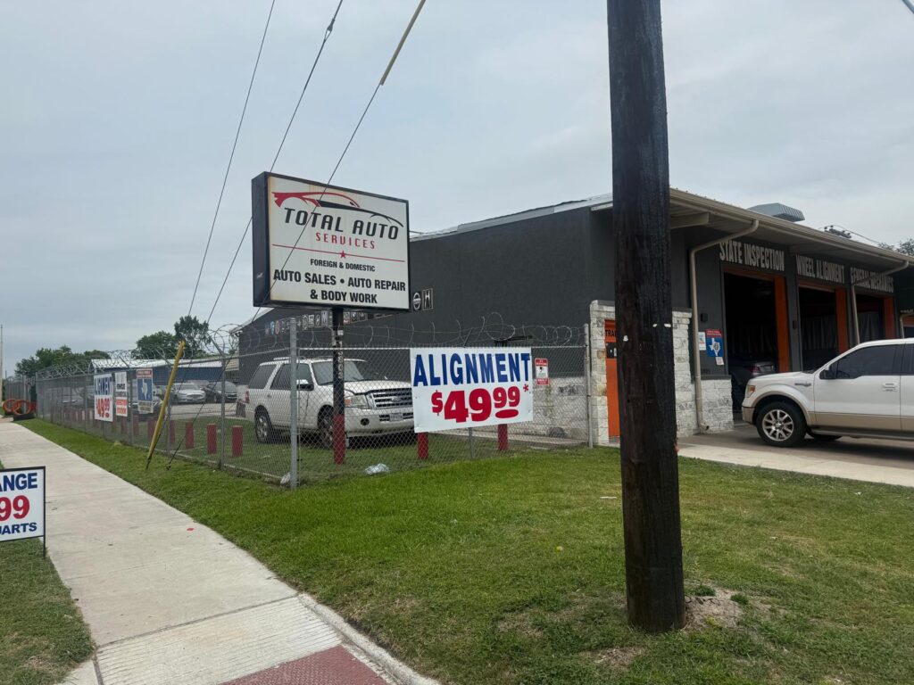 Auto repair shop with signage and parking lot.