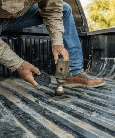 Man installing a custom truck bed with a hammer and tools.