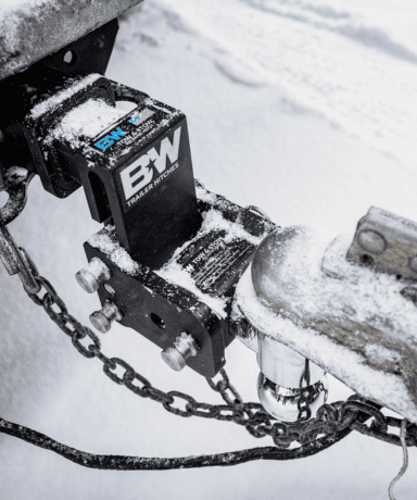 Custom trailer hitch with snow and ice buildup, designed for durability in winter weather.