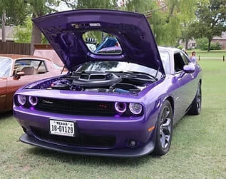 Custom purple Dodge Challenger with open hood showcasing engine.