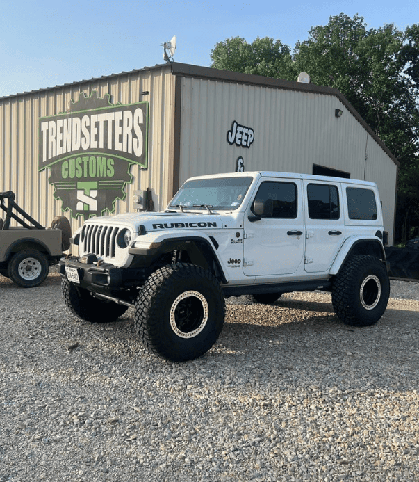Jeep Rubicon with custom modifications parked outside Trendsetters Customs, a specialist in vehicle.