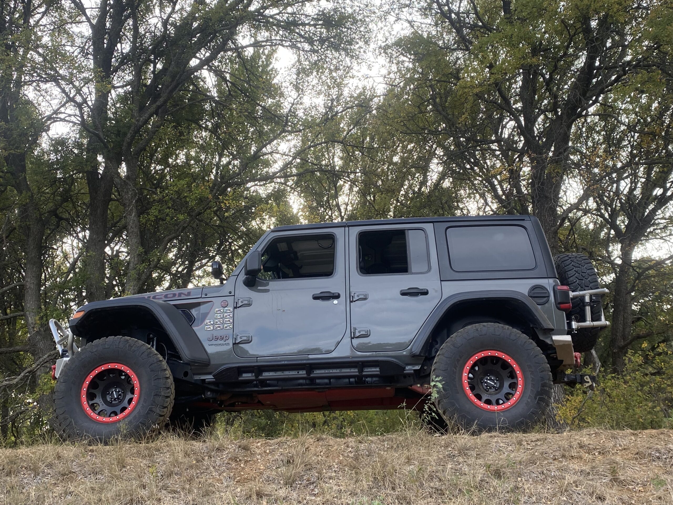 Custom Jeep Wrangler with off-road tires and lift kit for rugged terrain.