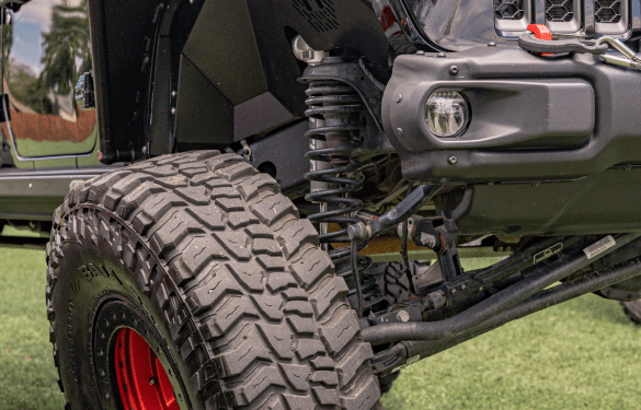 Off-road vehicle with custom tires and suspension for rugged terrain.