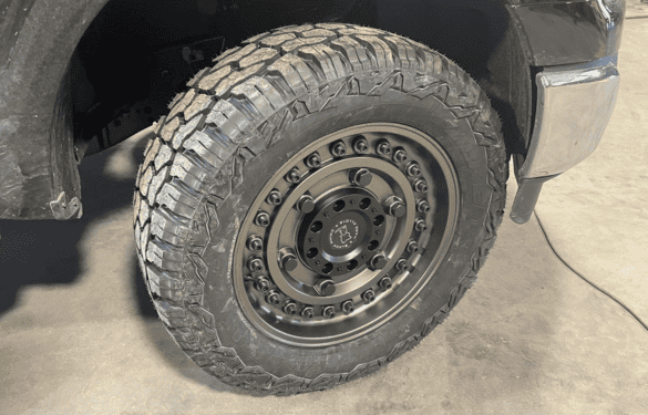 High-performance off-road tire with custom black wheel for trucks.