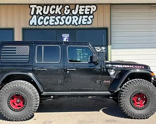 Black Jeep Gladiator with off-road tires and red accents, showcasing custom truck and Jeep accessori.