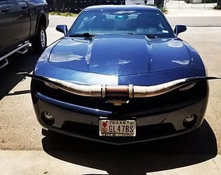 Customized blue sports car with unique exhaust system.