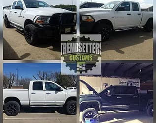 Customized white trucks with black accents and off-road features.
