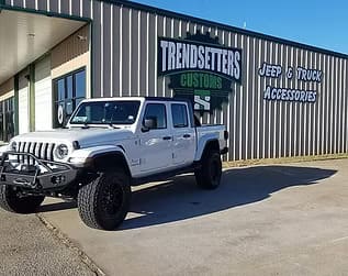 Custom Jeep truck parked outside Trendsetters Customs shop.