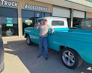 Vintage turquoise pickup truck at Trendsetters Customs shop.