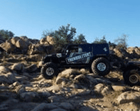RC off-road truck navigating rocky landscape.