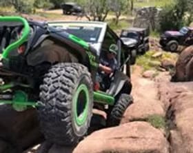 Off-road Jeep navigating rocky terrain with custom modifications.