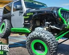 Off-road Jeep with custom green accents and rugged tires for adventurous terrain.