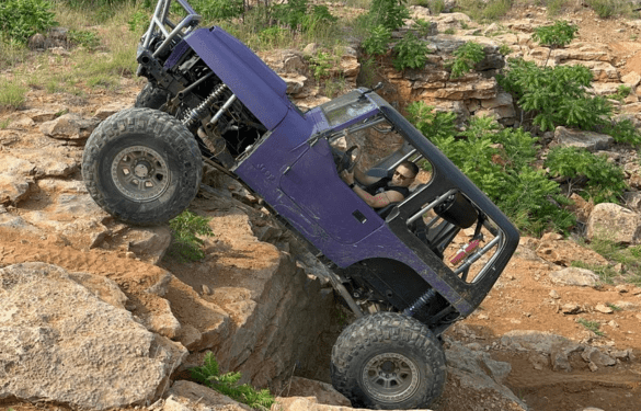Off-road customized Jeep climbing rocky terrain.