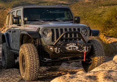 Modified Jeep Wrangler with off-road accessories and custom paint.
