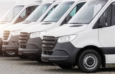 Lineup of white commercial vans for business transportation services.