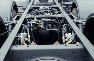 Close-up of a car chassis frame with suspension and engine components.