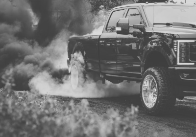Black diesel truck emitting smoke during a burnout.
