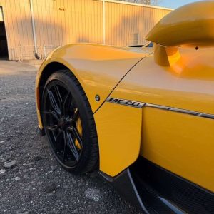 Yellow McLaren 720S sports car with black wheels and aerodynamic design.