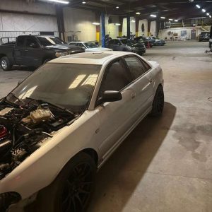 White sports car undergoing tuning and modifications at UAG Performance.