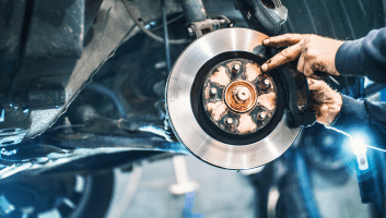 Skilled mechanic replacing a brake rotor on a vehicle for optimal safety and performance.