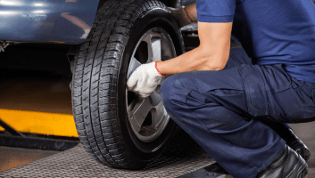 Technician performing wheel alignment on a vehicle at Uncle D’s Auto Repair.