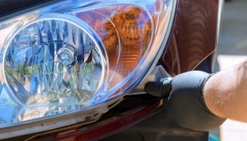 Technician restoring a car headlight for improved visibility and safety.