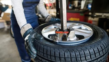 Technician mounting a tire onto a wheel at Universal Tire Tire Center.