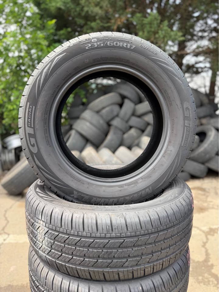 Stacked used tires with one tire showing size 235/60 R16 at Universal Tire Tire Center.