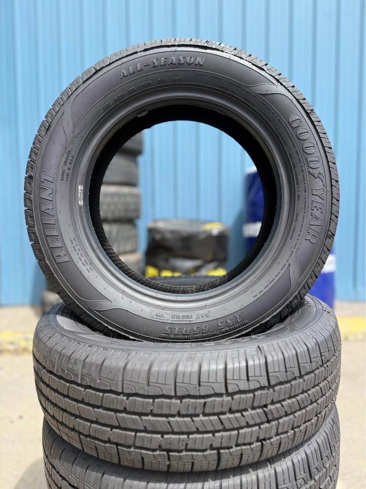 Stack of used tires at Universal Tire Tire Center in front of blue wall.
