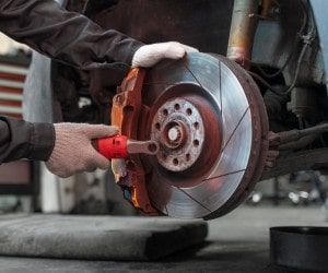 Skilled technician replacing brake rotor at Value Tires & Service.