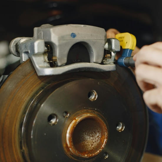 Close-up of brake rotor and caliper being serviced at Value Tires & Service.