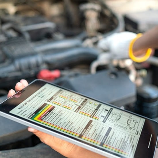 Car engine inspection report being reviewed under the hood.