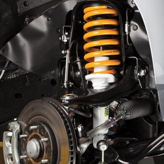 Suspension system with coil spring and shock absorber in a car.