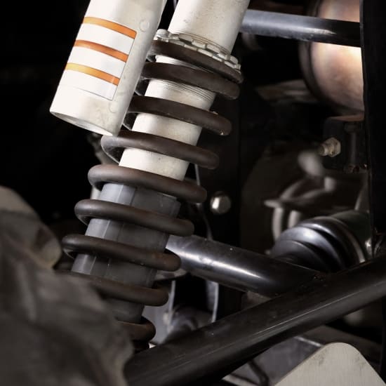 Suspension coil spring and shock absorber for vehicle ride comfort and stability.