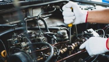 Engine repair, mechanic working on car engine, automotive maintenance at Vroom Auto.