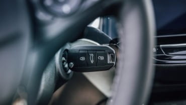 Close-up of car key fob with lock, unlock, and trunk buttons.