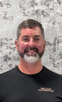 Vehicle service technician smiling at Wallace Automotive.