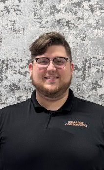 Friendly automotive technician at Wallace Automotive smiling in uniform.