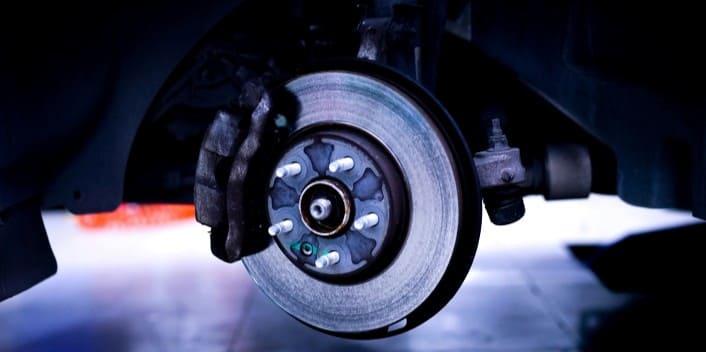 Brake disc and caliper close-up for vehicle maintenance.