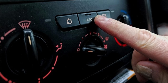 Close-up of a person adjusting the car's air conditioning settings at Wallace Automotive.