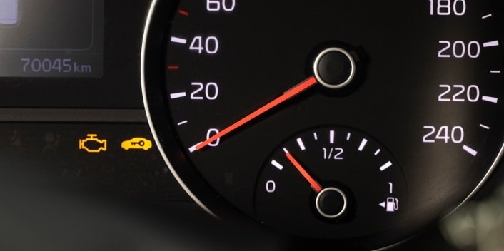 Dashboard warning lights and fuel gauge in a car at Wallace Automotive.